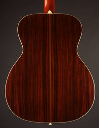 Back view of a acoustic guitar on a gray background