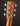 Close-up of a guitar headstock with tuning pegs on a dark background