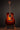 Acoustic guitar on a stand against a dark background