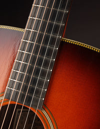 Close-up of a guitar's fretboard and soundhole on a dark background