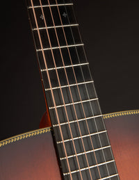 Close-up of a guitar neck with frets and strings on a dark background