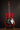 Red resonator guitar on a stand against a dark background