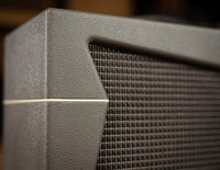 Close-up of a speaker grill on a vintage-style amplifier.