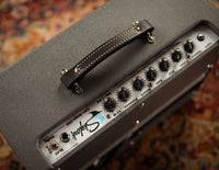 Close-up of a guitar amplifier with a brand logo on a patterned background