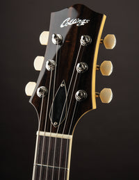Close-up of a guitar headstock with 'Collings' branding on a dark background