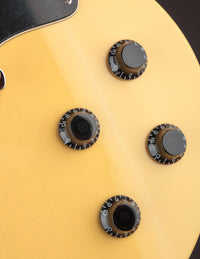 Close up of knobs on a TV yellow Collings 290 electric guitar with black pickguard 