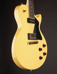 Side view of TV yellow Collings 290 electric guitar with black pickguard on a dark background