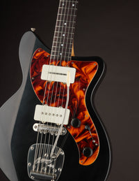 Electric guitar with a tortoiseshell pickguard on a dark background