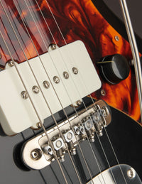 Close-up of a guitar's bridge and pickup.