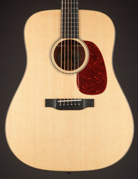 Acoustic guitar with a natural wood finish on a black background