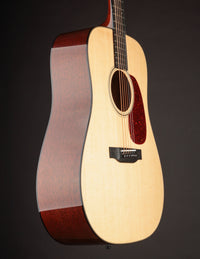 Acoustic guitar with a natural wood finish on a dark background