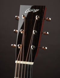 Close-up of a Collings guitar headstock with tuning pegs on a dark background