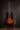 Acoustic guitar on a stand against a dark background
