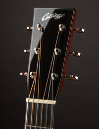 Close-up of a guitar headstock with 'Collings' branding on a dark background