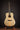 Acoustic guitar on a stand against a dark background