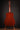 Acoustic guitar on a stand against a dark background