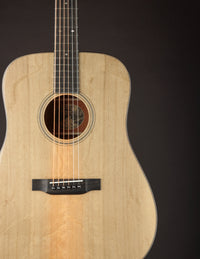 Acoustic guitar with a natural finish on a black background
