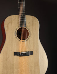 Acoustic guitar with a natural finish on a black background