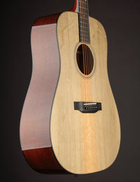 Acoustic guitar with a natural finish on a black background