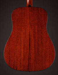 Back view of an acoustic guitar on a dark background