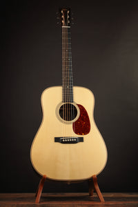 Collings acoustic guitar on a stand against a dark background (front)
