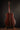 Collings acoustic guitar on a stand against a dark background (back)