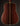 Back view of a Collings acoustic guitar on a dark background