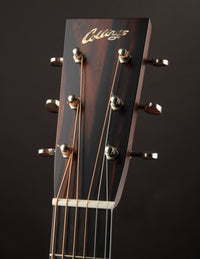 Close-up of a guitar headstock with 'Collings' branding on a dark background
