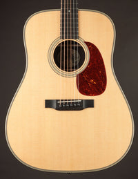 Collings acoustic guitar with a tortoiseshell pickguard on a dark background