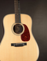 Collings acoustic guitar with a tortoiseshell pickguard on a dark background