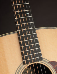 Close-up of a guitar's neck and soundhole on a dark background