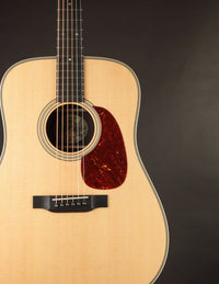 Collings acoustic guitar with a tortoiseshell pickguard on a dark background.