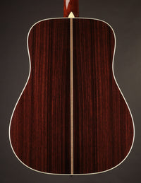 Back view of a Collings acoustic guitar on a gray background