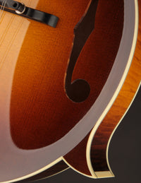 Close-up of the F-hole on a Collings mandolin with a dark background
