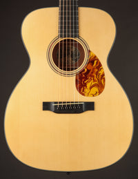 Collings acoustic guitar with a tortoiseshell pickguard on a black background