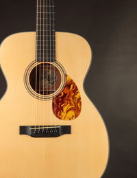 Side view of a Collings acoustic guitar with a sunburst finish on a black background.