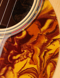 Close-up of tortoise shell pickguard on a Collings guitar.