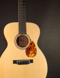 Collings acoustic guitar with a natural finish on a black background.