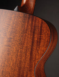 Close-up of a wooden guitar with a dark background