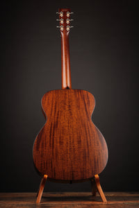 Back of Acoustic guitar in a Wooden Stand.