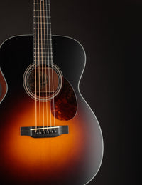 Acoustic guitar with a sunburst finish on a black background
