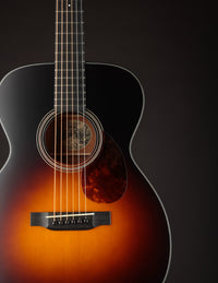 Acoustic guitar with a sunburst finish on a dark background