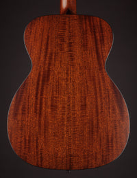 Close-up of a wooden guitar back with a dark brown background