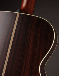 Close-up of a wooden acoustic guitar with a dark brown finish.