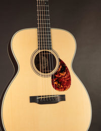 Acoustic guitar with a tortoiseshell pickguard on a dark background