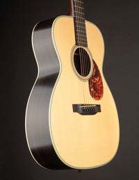 Acoustic guitar with a tortoiseshell pickguard on a dark background