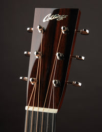 Close-up of a guitar headstock with 'Collings' branding on a dark background