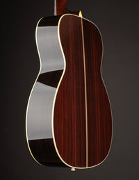 Acoustic guitar on a black background, side view