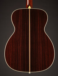 Back view of an acoustic guitar on a dark background