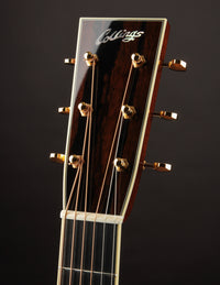 Close-up of a guitar headstock with 'Collings' branding on a dark background